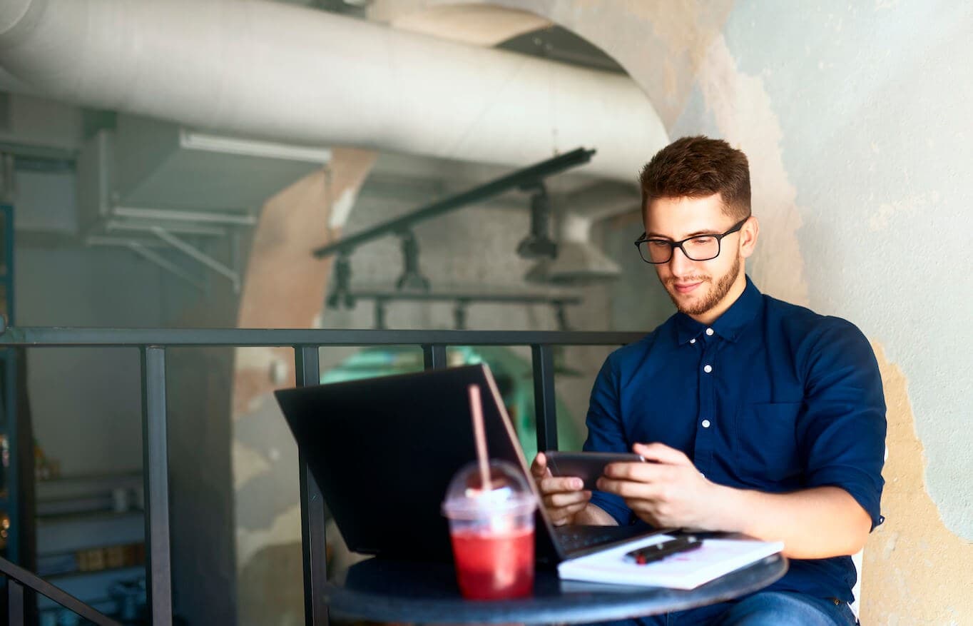 Man using devices on small table