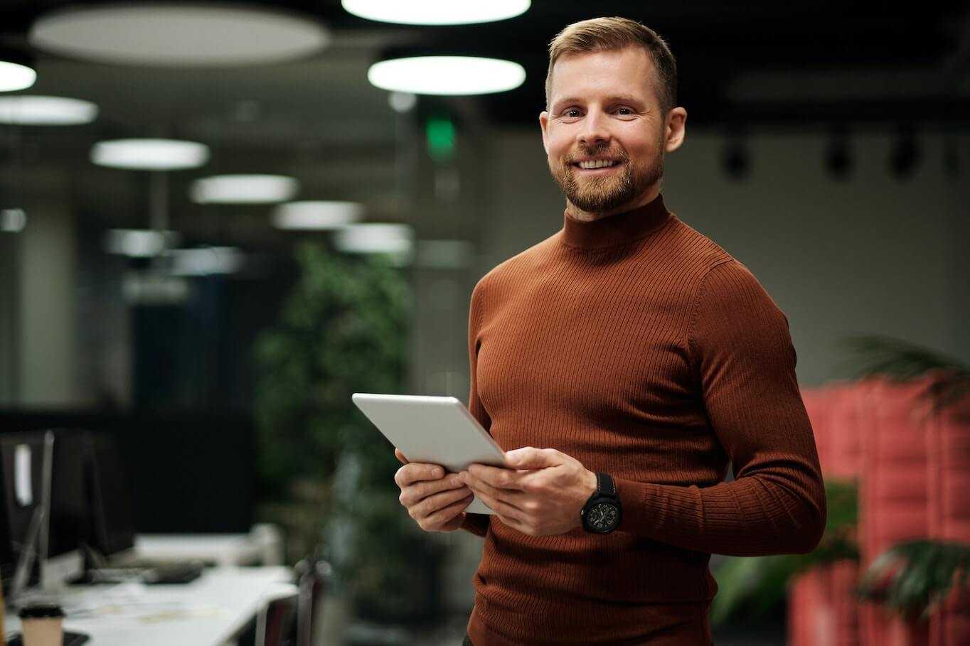 Man holding tablet smiling green back