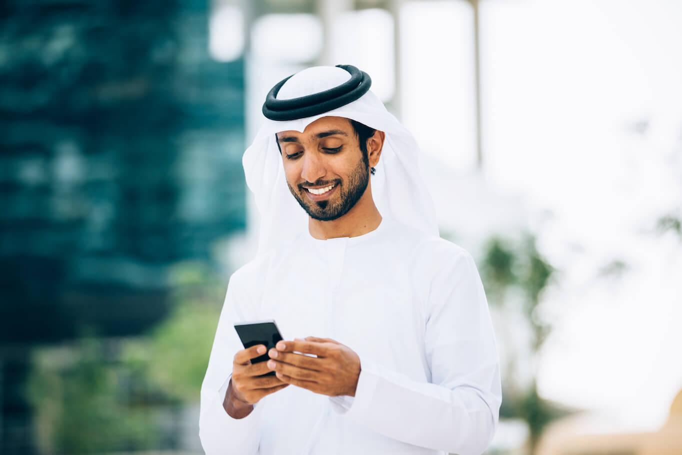Man in white holding smartphone